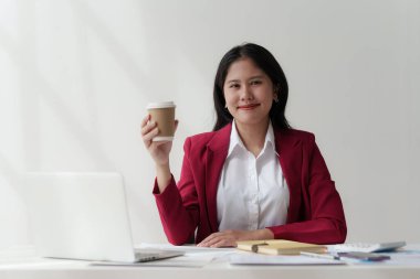 Gülümseyen Asyalı Muhasebeci mali raporu analiz eder ve yıllık rakamları inceler, karı analiz eder.