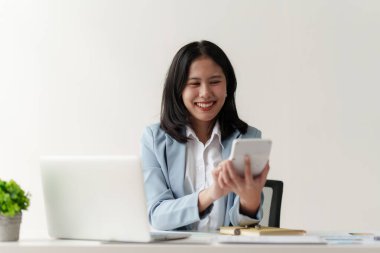 Gülümseyen Asyalı Muhasebeci mali raporu analiz eder ve yıllık rakamları inceler, karı analiz eder.