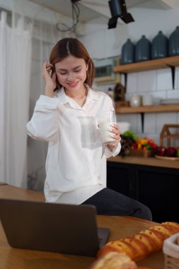 Bir kadın canlı mutfağında taze salata yerken sağlıklı beslenmenin zevkini keşfedin. Vücudunu besle ve lezzetli, besleyici yemeklerle sağlıklı bir yaşam tarzını benimse.