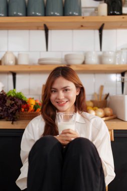 Bir kadın canlı mutfağında taze salata yerken sağlıklı beslenmenin zevkini keşfedin. Vücudunu besle ve lezzetli, besleyici yemeklerle sağlıklı bir yaşam tarzını benimse.