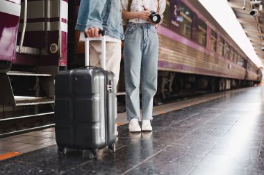 Tren istasyonundaki Asyalı çift çok mutlu. Turizm ve yaz seyahatleri.