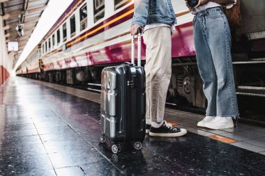 Tren istasyonundaki Asyalı çift çok mutlu. Turizm ve yaz seyahatleri.