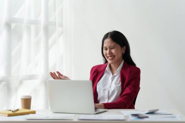 Gülümseyen Asyalı Muhasebeci mali raporu analiz eder ve yıllık rakamları inceler, karı analiz eder.