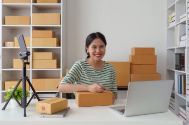 Laptop ve paket kutusu olan bir iş kadını. E-Ticarette KOBİ Başarı Sembolü