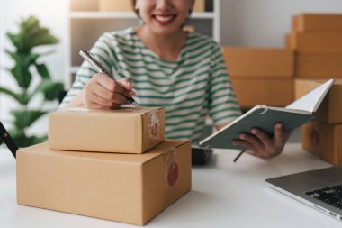 Laptop ve paket kutusu olan bir iş kadını. E-Ticarette KOBİ Başarı Sembolü