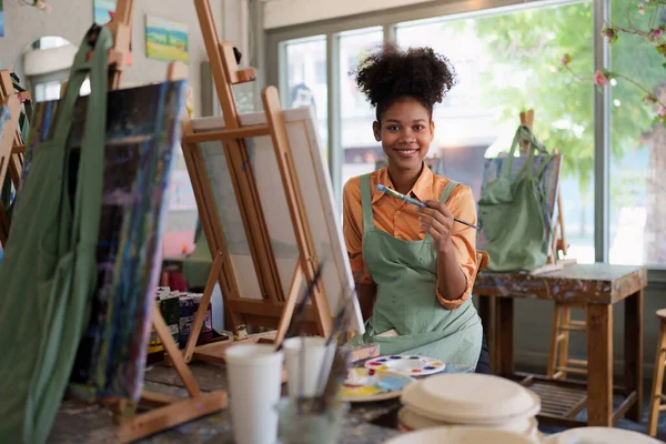 stock image Beautiful american african artist woman painting in art studio at the university classroom.