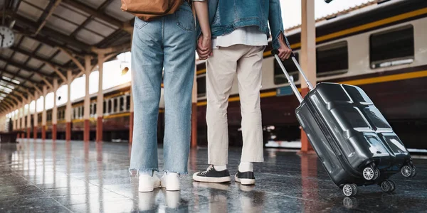 Tren istasyonundaki Asyalı çift çok mutlu. Turizm ve yaz seyahatleri.