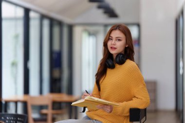 Sınıfta güzel, Asyalı bir üniversite öğrencisi. Üniversite kampüsünde çalışan bir üniversite öğrencisi. okul konseptine geri dön.