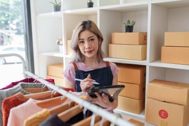 Asyalı kadın moda tasarımcısı bir moda stüdyosunda yeni bir elbise tasarlıyor..