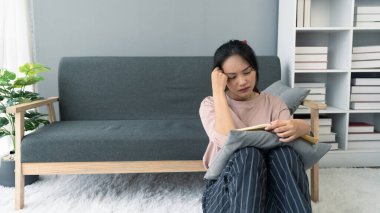 Asyalı genç kadın kitap okurken stres yapıyor.