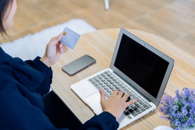 Genç bir kadın internet sitesinden online alışveriş için kredi kartı kullanıyor. Çevrimiçi alışveriş, e-ticaret, internet bankacılığı, harcama..