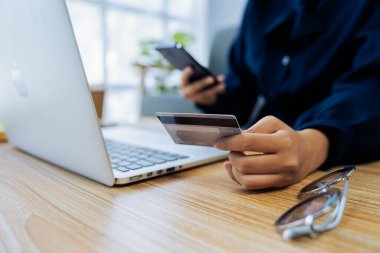Genç bir kadın internet sitesinden online alışveriş için kredi kartı kullanıyor. Çevrimiçi alışveriş, e-ticaret, internet bankacılığı, harcama..