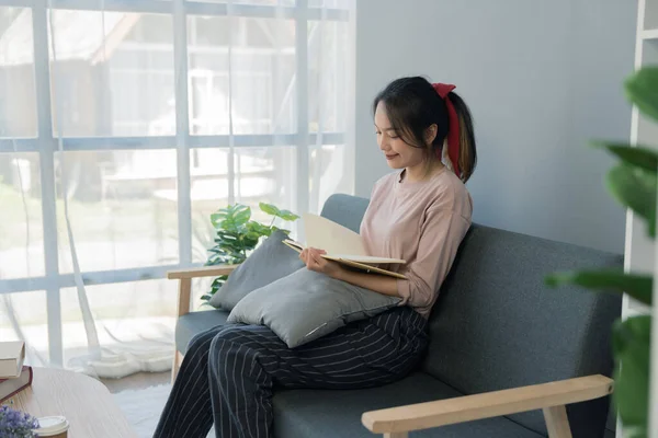 Νεαρή Ασιάτισσα Διαβάζει Ένα Βιβλίο Στο Σπίτι Της Κάθεται Στον — Φωτογραφία Αρχείου