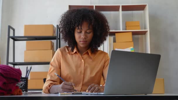 美丽的美籍非洲妇女创办了小企业 一个女人在家里工作 在网上递送包裹 企业家 中小企业交付概念 — 图库视频影像