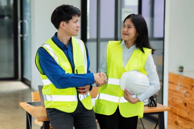 İnşaat mühendisleri ve mimarlar ofiste çalıştıktan sonra el sıkışıyorlar..