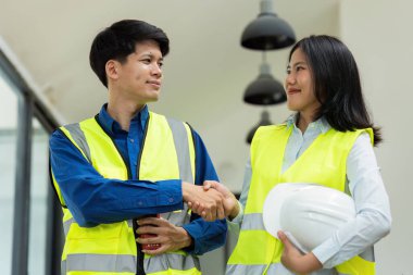 İnşaat mühendisleri ve mimarlar ofiste çalıştıktan sonra el sıkışıyorlar..