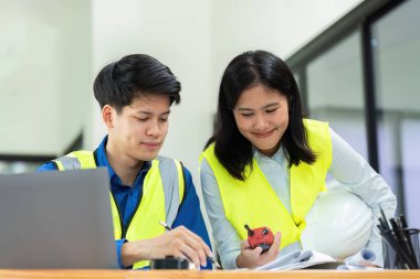 İnşaat mühendisleri ve mimarlar proje inşaatını ofiste ve telsiz başında tartışırlar..