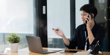 Genç işadamının elinde belge ve kalem vardı. Akıllı telefonda önemli şeyler hakkında konuşuyordu..