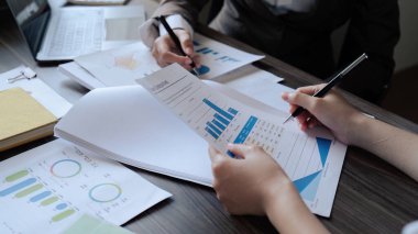 Şef ve çalışanın yakın çekimi ofiste aylık kazanç grafiğini tartışır..