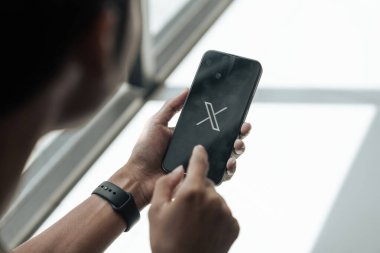 CHIANG MAI, THAILAND - 28 Temmuz 2023: Twitter logosu olan bir Apple iPhone tutan adam. Twitter, mikroblog ve ağ iletişimi için bir sosyal medya hizmetidir...