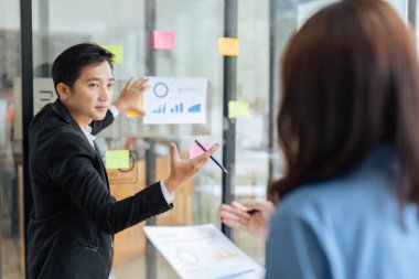 Belgeleri grafikle gösteren iş adamları. Şirketlerin gelirlerindeki istikrarlı artışı sunar.