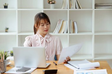 Ofis içinde evrak işi yapan bir çalışan, kadın finansör sözleşmeleri ve grafiklerle ilgili raporları düşünüyor, başarılı kadın iş yerinde dizüstü bilgisayar kullanıyor..