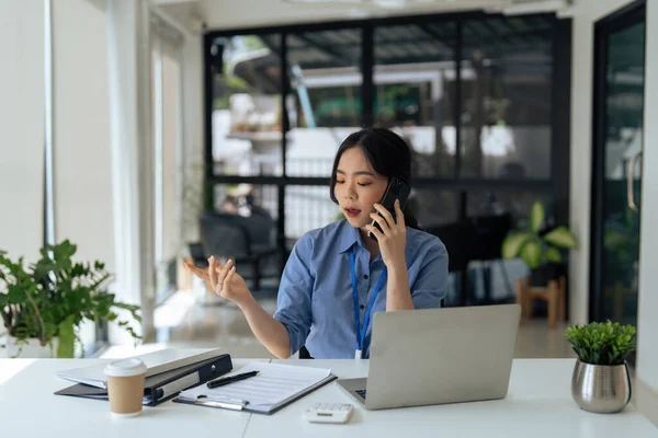 Młoda Bizneswoman Azjatycki Rozmowy Klientem Przez Telefon Komórkowy Siedzi Biurku — Zdjęcie stockowe