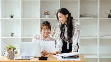 Ofiste birlikte çalışan iş adamları dizüstü bilgisayara bakarak ve ofiste yeni projeleri tartışarak yeni projeler planlıyorlar...