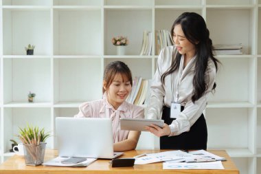 Ofiste birlikte çalışan iş adamları dizüstü bilgisayara bakarak ve ofiste yeni projeleri tartışarak yeni projeler planlıyorlar...