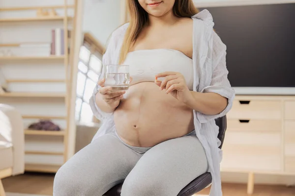 妊娠中の女性は 未熟児に栄養を与えるためにビタミンと水を飲む — ストック写真
