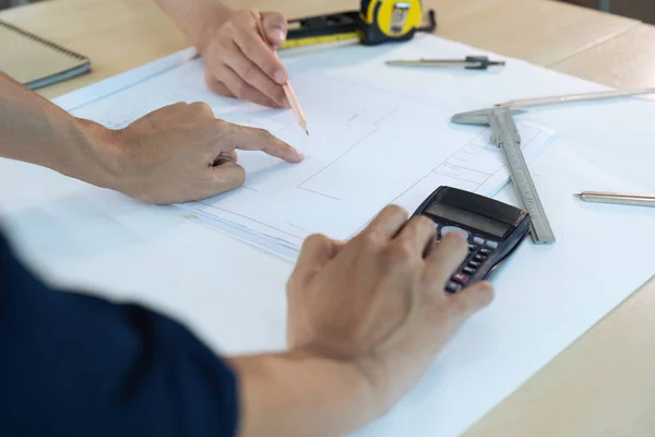 stock image Architect man holding pencil working with blueprints for architectural plan.