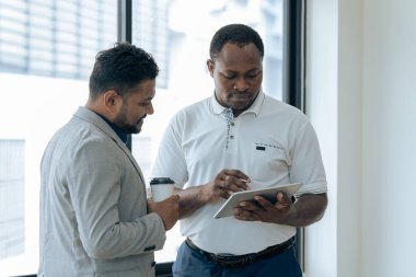 İki mutlu iş arkadaşı tablet üzerinde mali raporları tartışıyor, proje üzerinde birlikte çalışıyorlar..