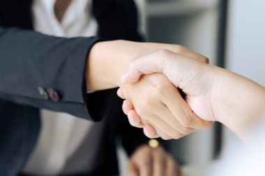 Ofis toplantısında el sıkışan iki profesyonel iş kadını yönetici lider..