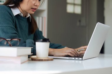 Genç adam çevrimiçi kursu öğrenmek için dizüstü bilgisayar kullanıyor, bilgi arıyor.