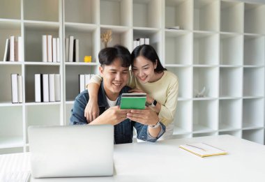 Genç çift, geleceklerini birlikte planlamak için hesap defterindeki paraya bakar..