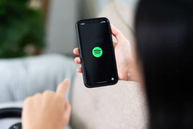 CHIANG MAI, THAILAND, Sep 06, 2023: 9 numaralı Samsung notunu tutan kadın ekranda Spotify logosu var. Spotify popüler bir müzik servisidir...