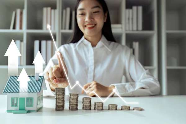 Kâr grafiği olan madeni para ve ev modeli. mortgage ve gayrimenkul yatırımları.
