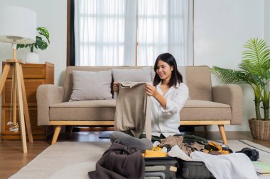 Genç bayan yere otur ve hafta sonu gezisi için bavul hazırla...