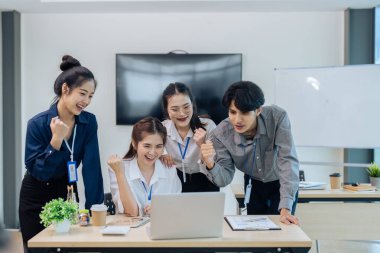 Girişimci gençler ve ortaklar toplantı odasında başarılı bir proje yaparken kutlama yapıyorlar.
