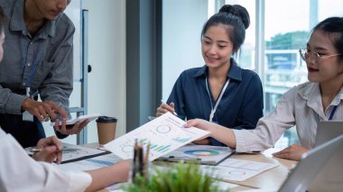 Girişimci gençler ve ortaklar toplantı odasında başarılı bir proje yaparken kutlama yapıyorlar.
