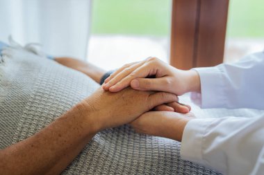 Doktorlar ya da hemşireler yaşlı hastaların elini tutup onları yatıştırır..