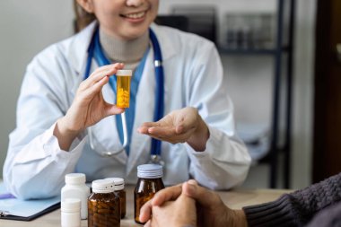 Kadın doktor yaşlı hastalara günlük ilaç ve vitamin verilmesini tavsiye eder.