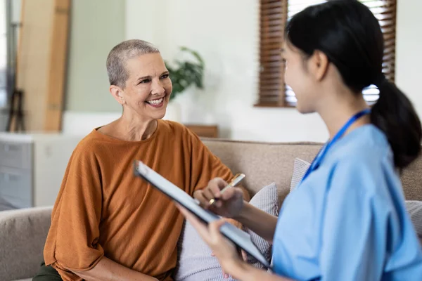 nursing clipboard and elder woman with insurance for home and support with a smile on a couch.