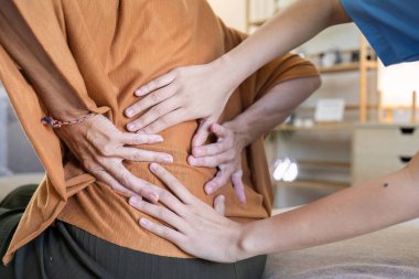 Yaşlı kadınların kemik iltihabı nedeniyle sırt ağrıları var ve semptomlarını fizyoterapi için doktor muayene ediyor..