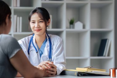 Steteskoplu beyaz üniformalı doktor terapisti hasta ellerine dokunuyor..