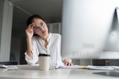 Ofisteki genç Asyalı iş kadını muhasebeci bilgisayar ekranına bak sorun çözümü hakkında düşün..