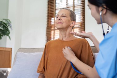 Yaşlı Kafkasyalı nefes alırken doktor evdeki sağlık hizmeti ile kalp atışlarını kontrol ediyor..
