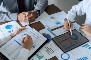 Toplantı masasında analiz maliyeti grafiği olan iş adamları takım çalışması.