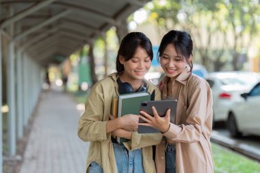 Üniversite öğrencileri bir sonraki derse yürürken dijital tablet kullanıyorlar.