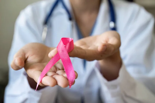 Pembe Ekim Kanser Farkındalığı Ayı. Pembe kurdeleli doktor, insanların yaşam ve hastalıklarını desteklemek için hastanede..